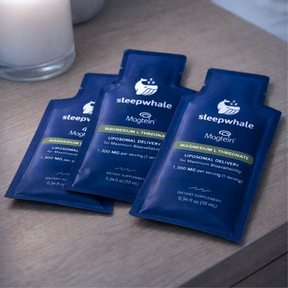 Three blue packets of Magtein on a wooden surface.